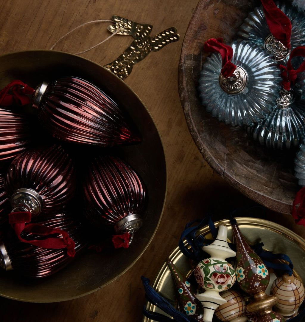 Ribbed glass ornaments is a warm chocolate and sea blue displayed in rustic bowls