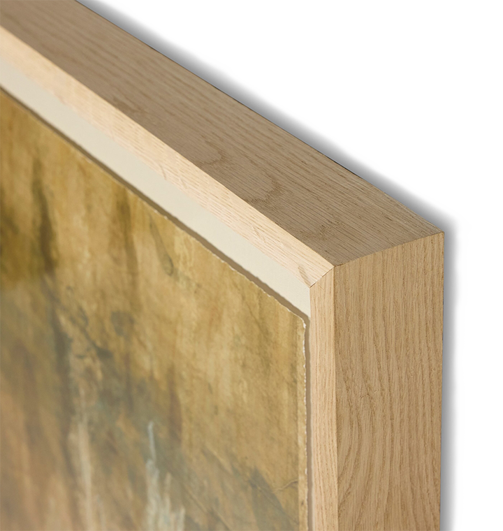 Close-up of a framed artwork corner showing a light natural wood frame with a textured gold-toned painting inside, on a white background.