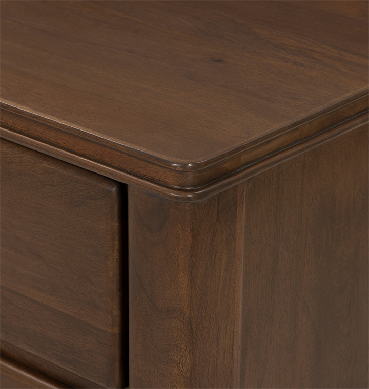 A close up corner view of a wooden nightstand.