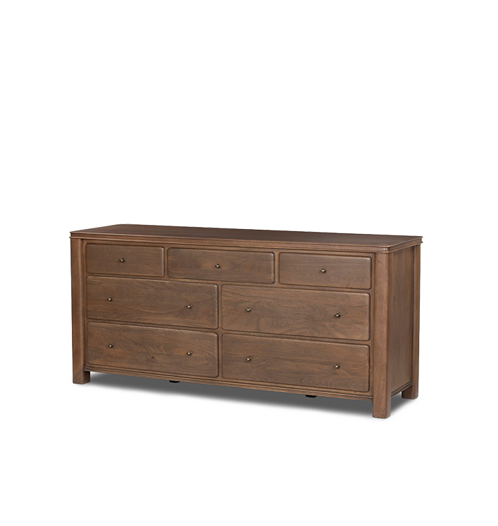 An angled view of a seven-drawer wooden chest of drawers with small round brass knobs, shown against a plain light gray background.