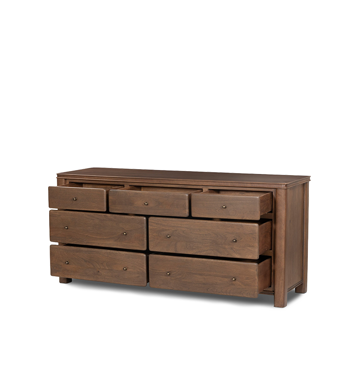 An angled open drawer view of a five-drawer wooden chest of drawers with small round brass knobs, shown against a plain light gray background.