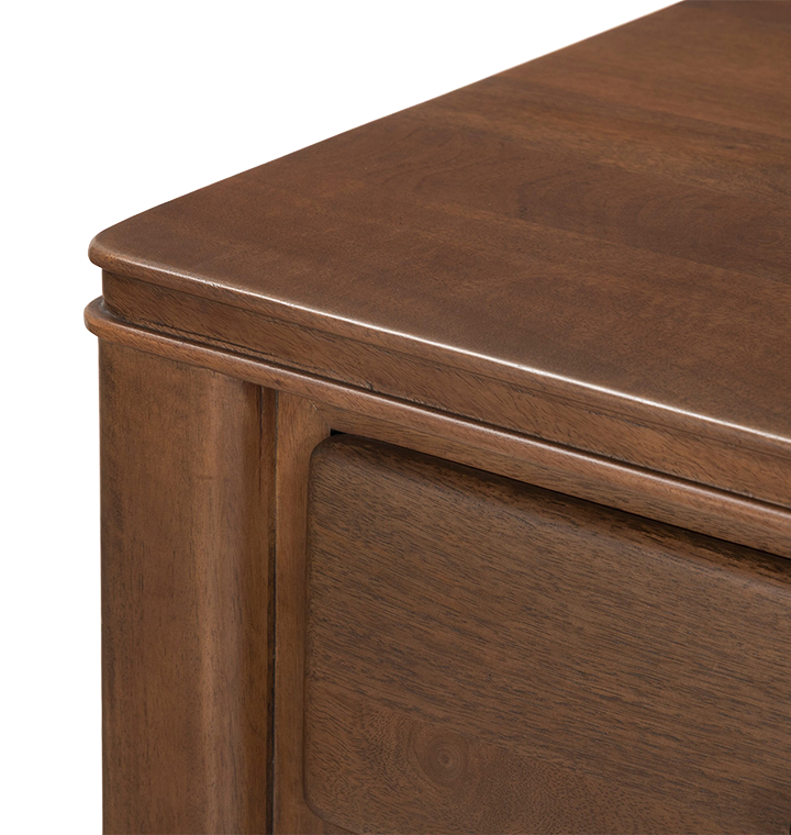 A close up view of a wooden dresser with small round brass knobs, shown against a plain light gray background.