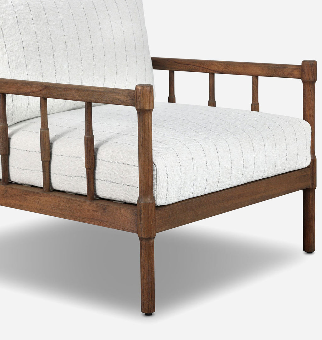 A close-up of a wooden outdoor armchair with a warm brown frame and off-white striped cushions, shown against a light gray background.