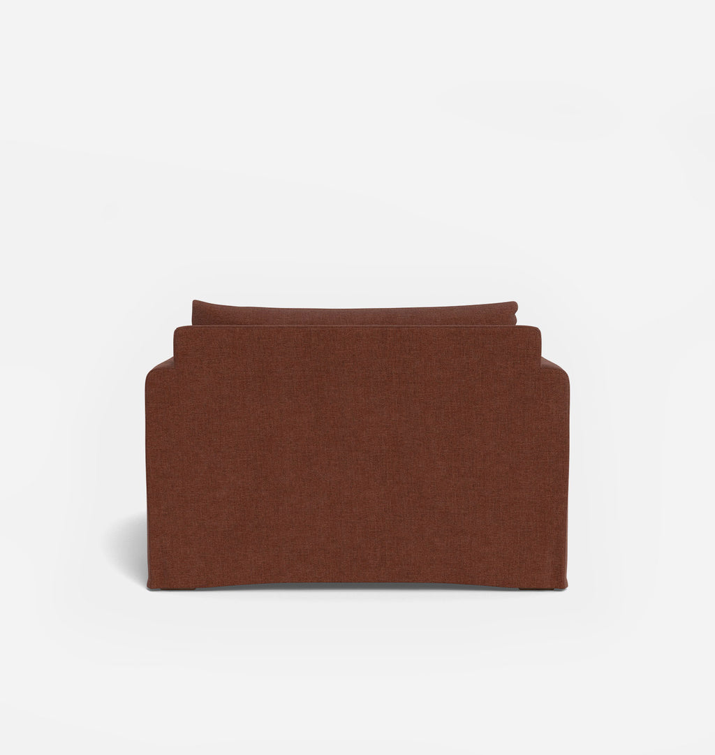 A single upholstered chaise lounge chair shown from the back on a clean white studio background. The chair has a warm rust-brown fabric.