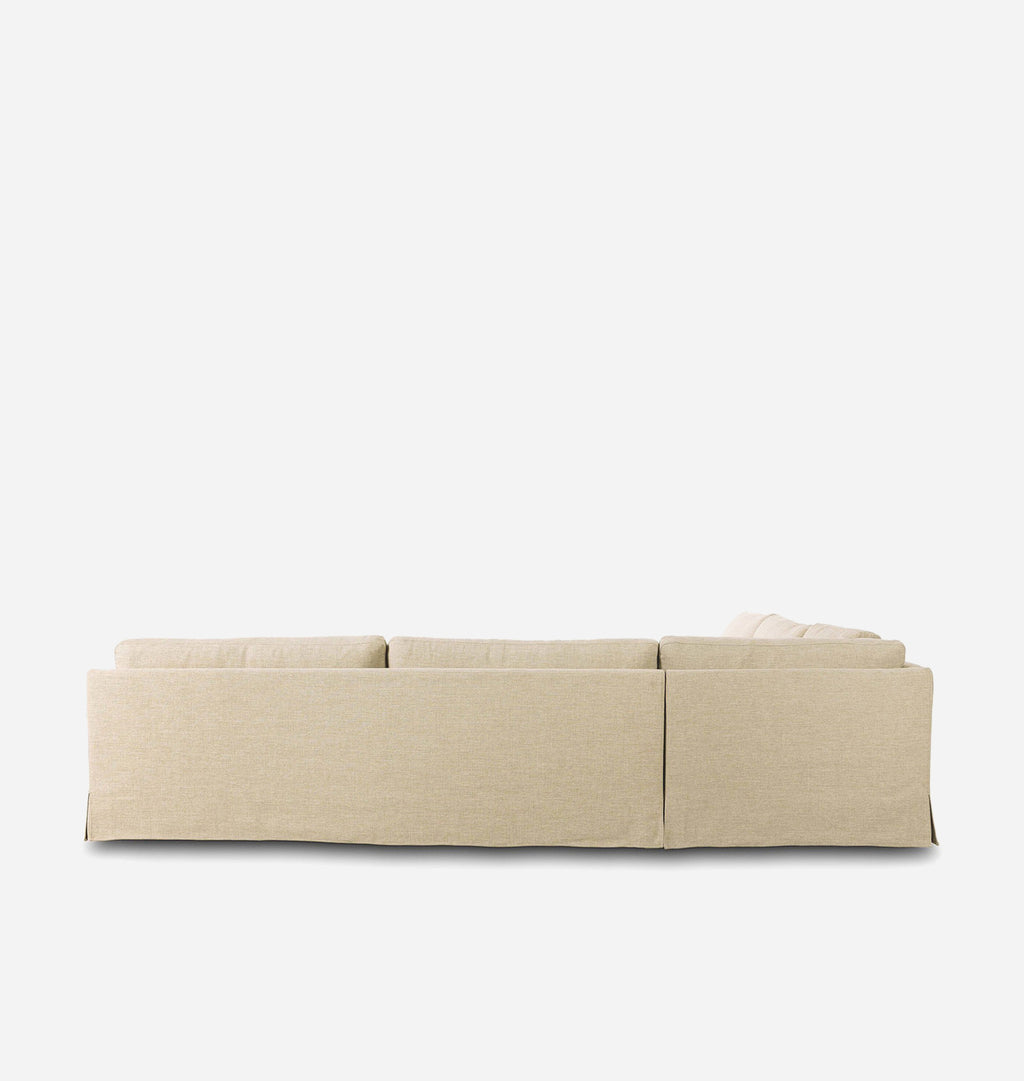 A low-profile sectional sofa upholstered in a light beige textured fabric, shown from a direct rear three-quarter angle against a solid white background.
