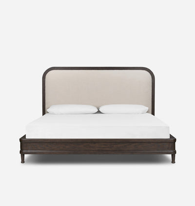 A modern platform bed with a dark wood frame and a tall, curved upholstered headboard in a light beige fabric, shown with a white mattress and two white pillows against a plain white background.