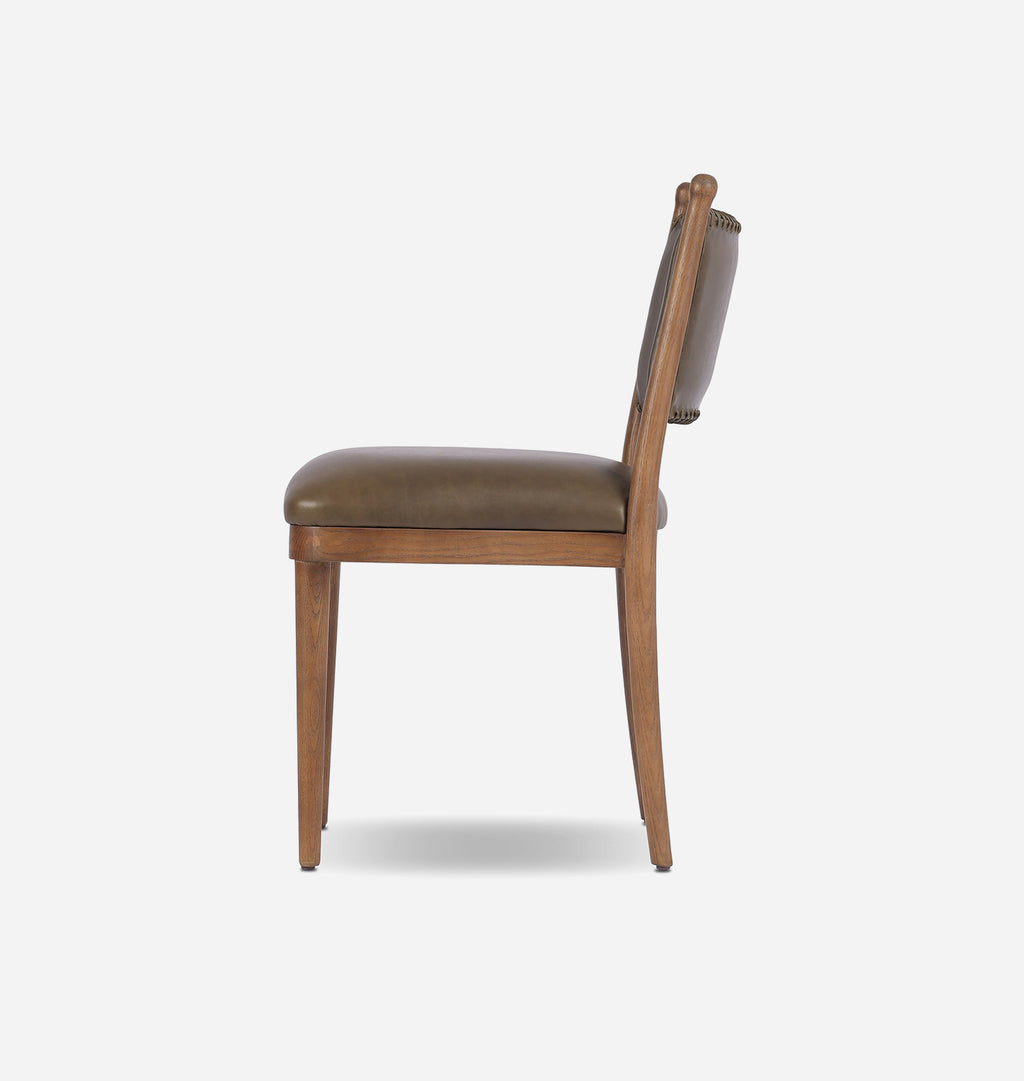 A side-view shot of a wooden dining chair with a brown upholstered seat and backrest, set against a plain light gray background.