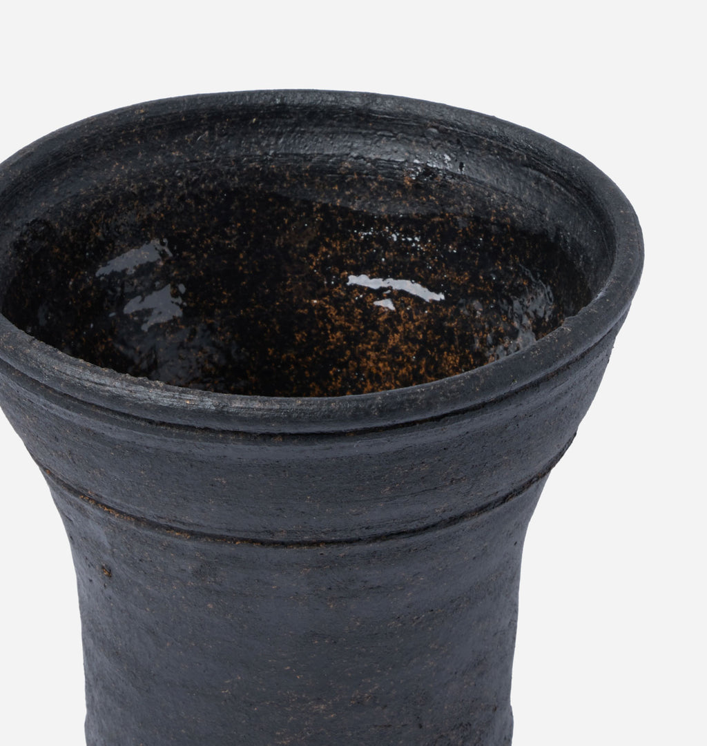 Close-up of a dark charcoal gray ceramic planter or vase with a textured matte finish and subtle orange-brown speckling inside the glazed interior, shown against a plain white background.