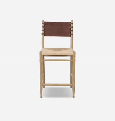 A mid-century modern bar stool with a light natural wood frame, a woven beige rope seat, and a brown leather sling backrest, shown against a plain light gray background.