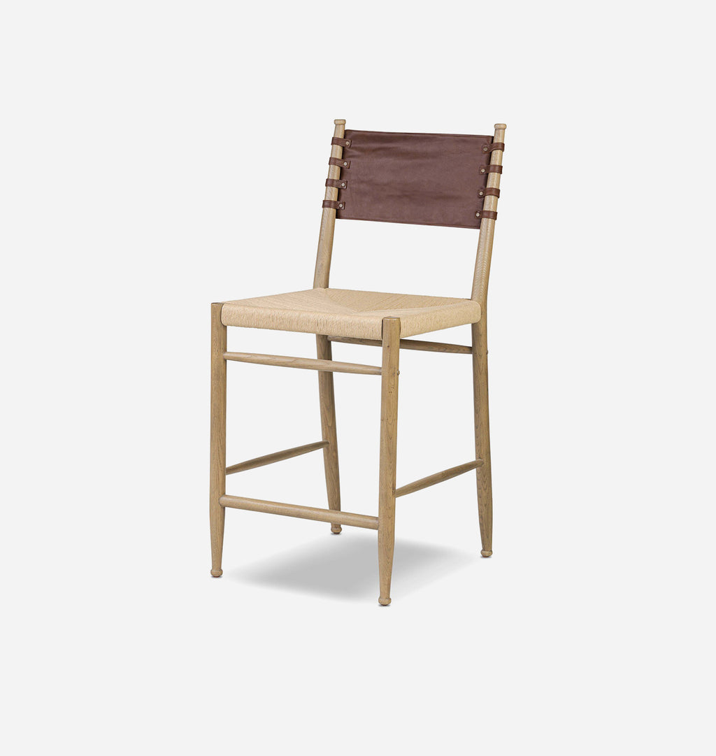 A modern wooden barstool with a light natural wood frame, a woven beige seat, and a dark brown sling backrest, shown on a light gray background.