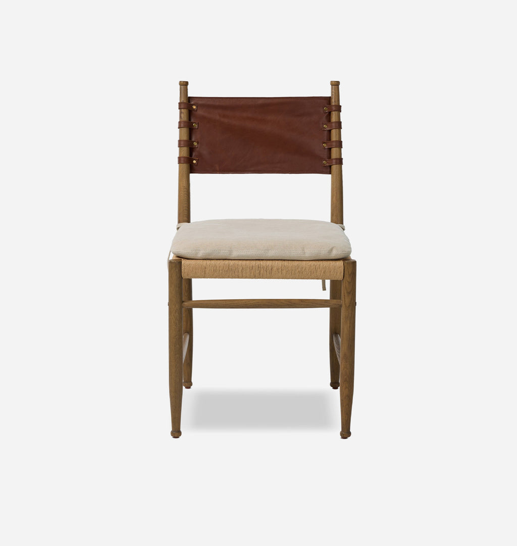 A mid-century modern wooden dining chair with a brown leather sling backrest, a cream upholstered seat cushion, and a natural wood frame, shown against a light gray background.