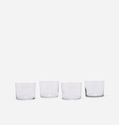 Four clear glass tumblers arranged in a row against a plain white background.