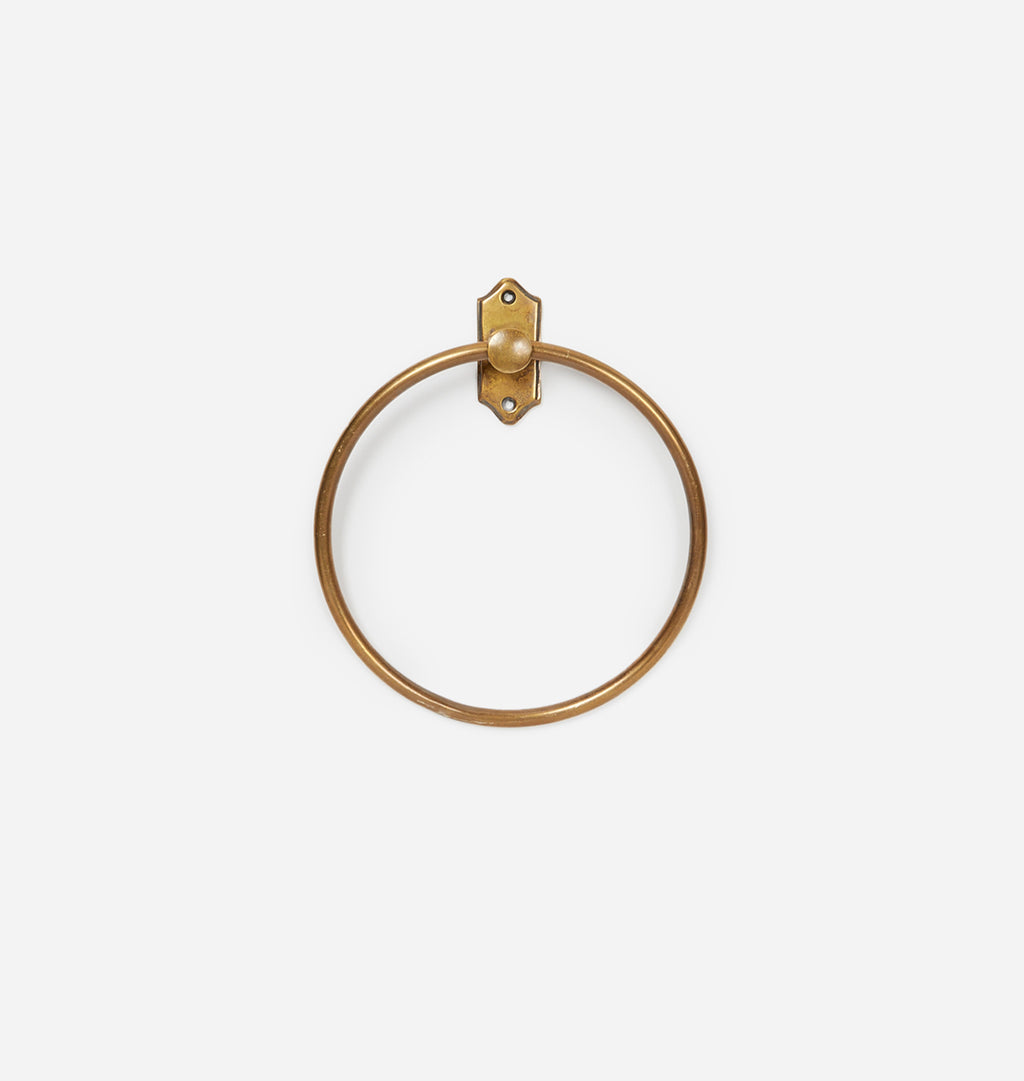 A single brass wall-mounted ring with a decorative bracket, shown against a plain light gray background.