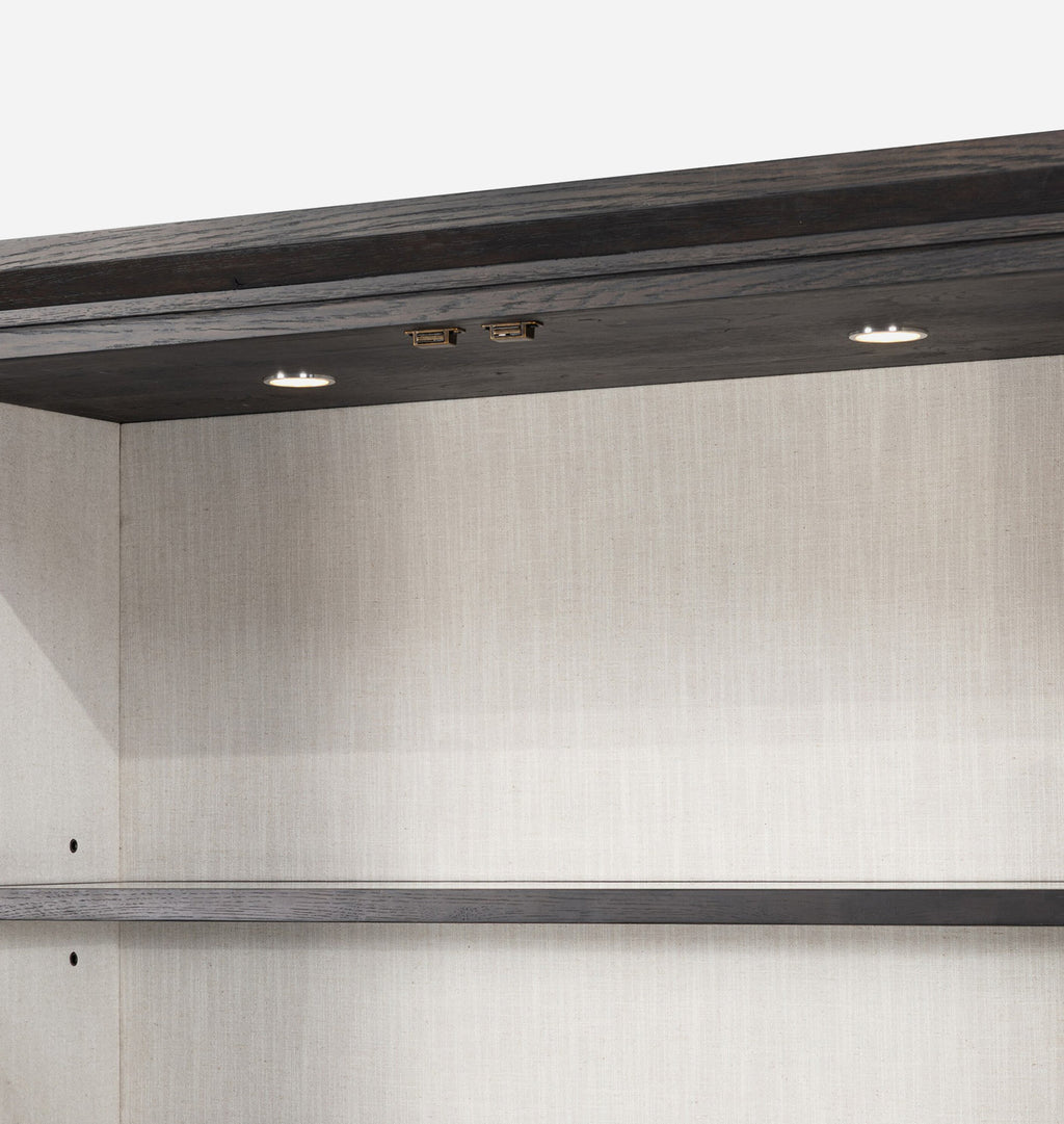 Close-up of the interior upper shelf of a storage cabinet or closet organizer, showing a dark wood shelf frame with integrated LED lighting and a light beige textured back panel.