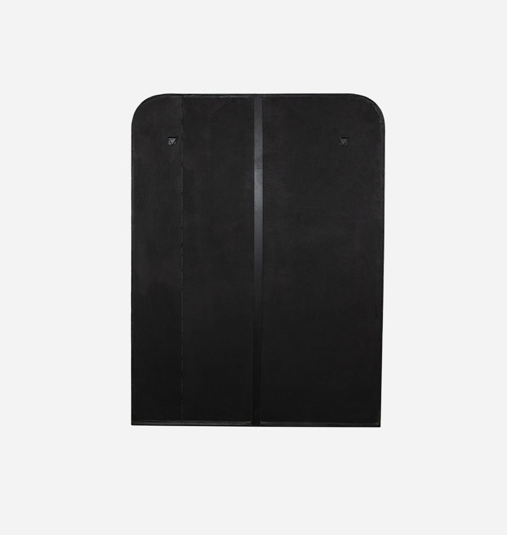 A back view of an oversized black aluminium floor mirror with curved corners and a thick frame set against a white background