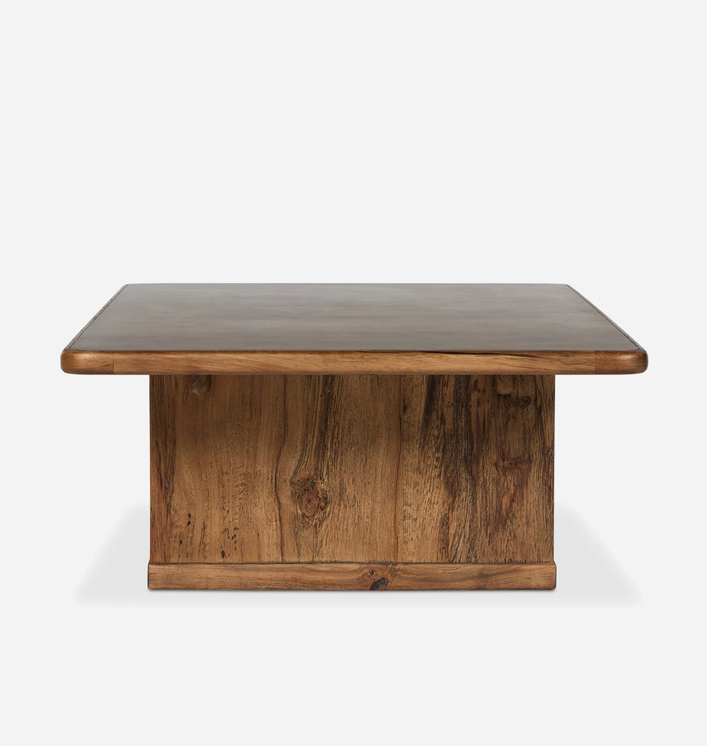 A wooden coffee table with a thick, rounded edge top and a solid pedestal base, shown against a plain light gray background.