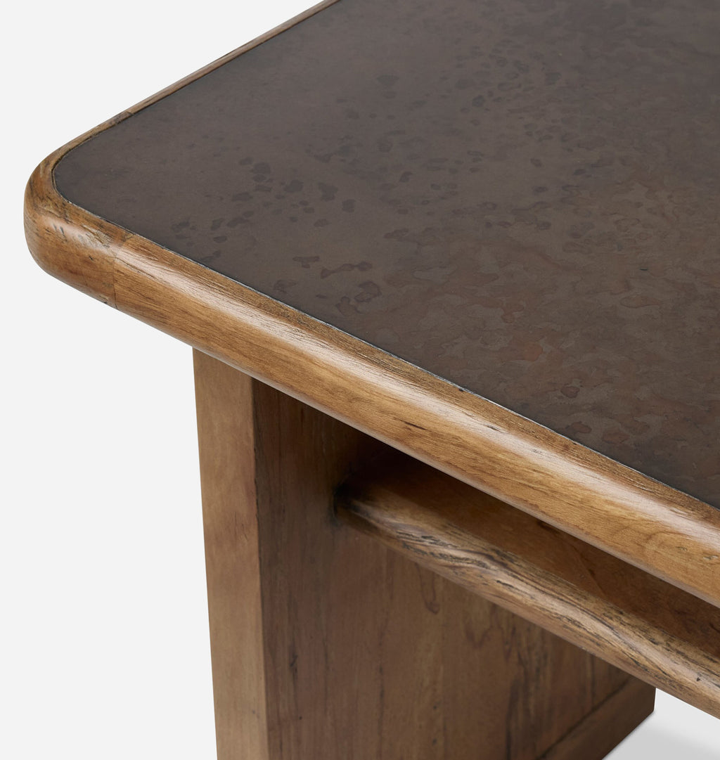 Close-up of a rustic wooden table corner with a dark brown textured tabletop and a warm medium-brown wood frame, shown on a light gray background.