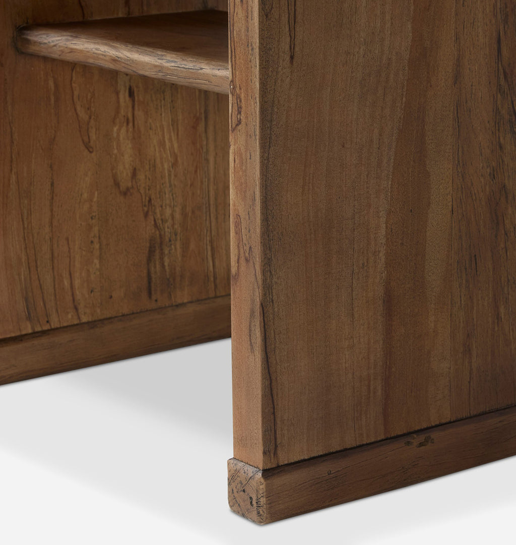 Close-up detail of a rustic wooden furniture piece, showing the corner joint and grain of medium brown wood on a white background.