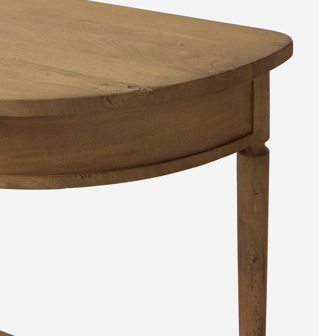 Close-up of a light brown wooden table corner showing the curved tabletop, apron, and leg against a plain white background.