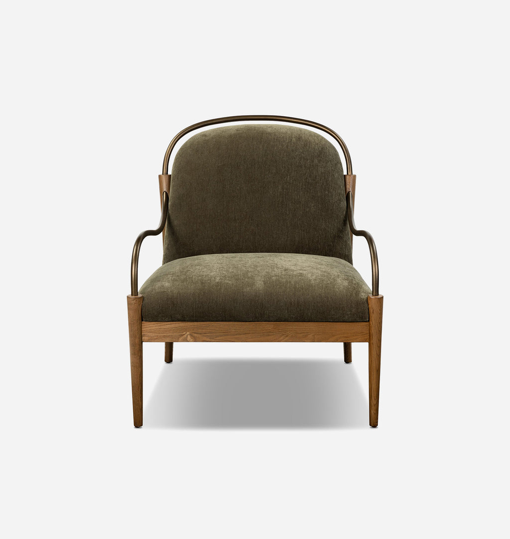 A modern accent chair with a dark olive green velvet upholstered seat and backrest, supported by a light brown wooden frame with curved dark metal armrests, shown against a plain white background.