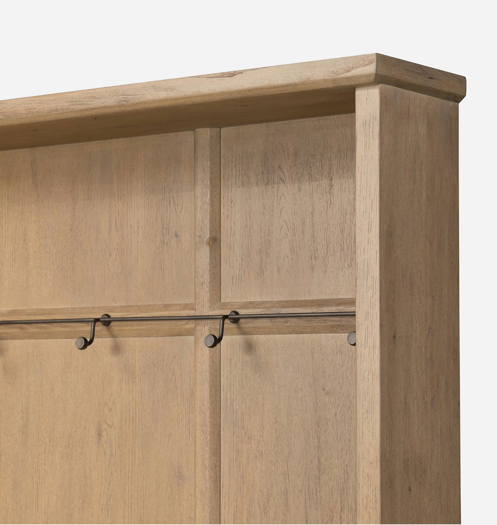 Close-up of a light oak wood coat rack with a top shelf, hanging hooks, and a vertical side post on a white background.