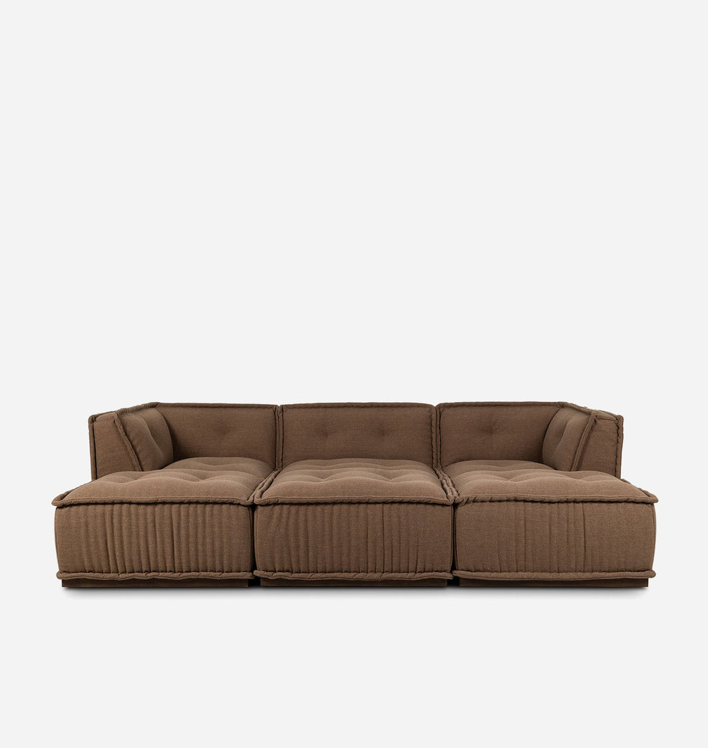A three-seater modular sofa upholstered in a textured brown fabric, featuring tufted back cushions and vertically ribbed front panels, shown against a plain light gray background.