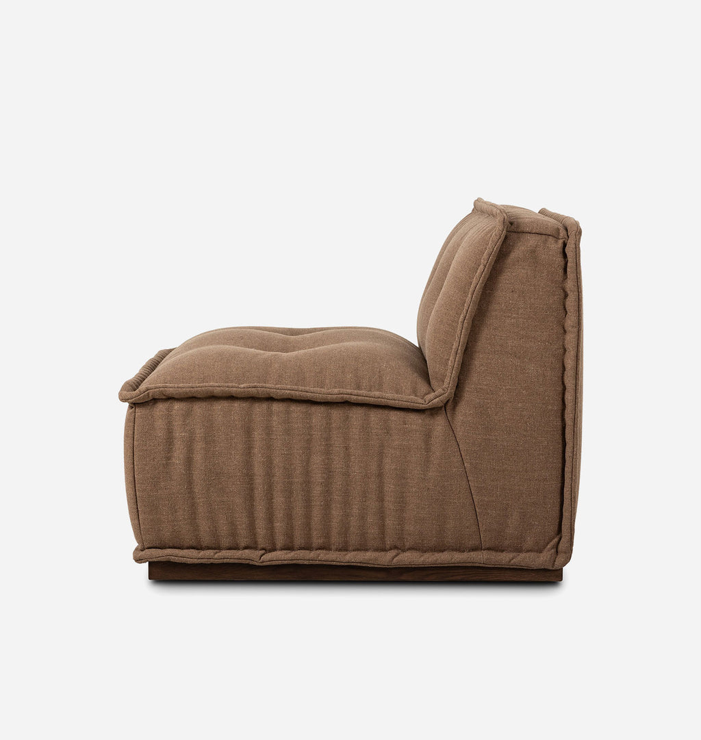 A low-profile, square-shaped upholstered lounge chair in a warm brown fabric, shown from a side profile view against a plain white background.