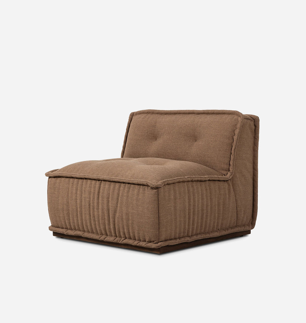 A low-profile, square-shaped upholstered lounge chair in a warm brown fabric, shown from an angled profile view against a plain white background.