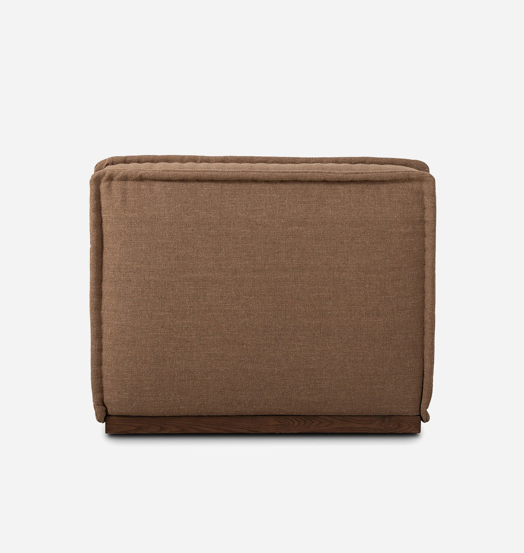 A square upholstered chair in a warm brown fabric, shown from the back against a clean white background.