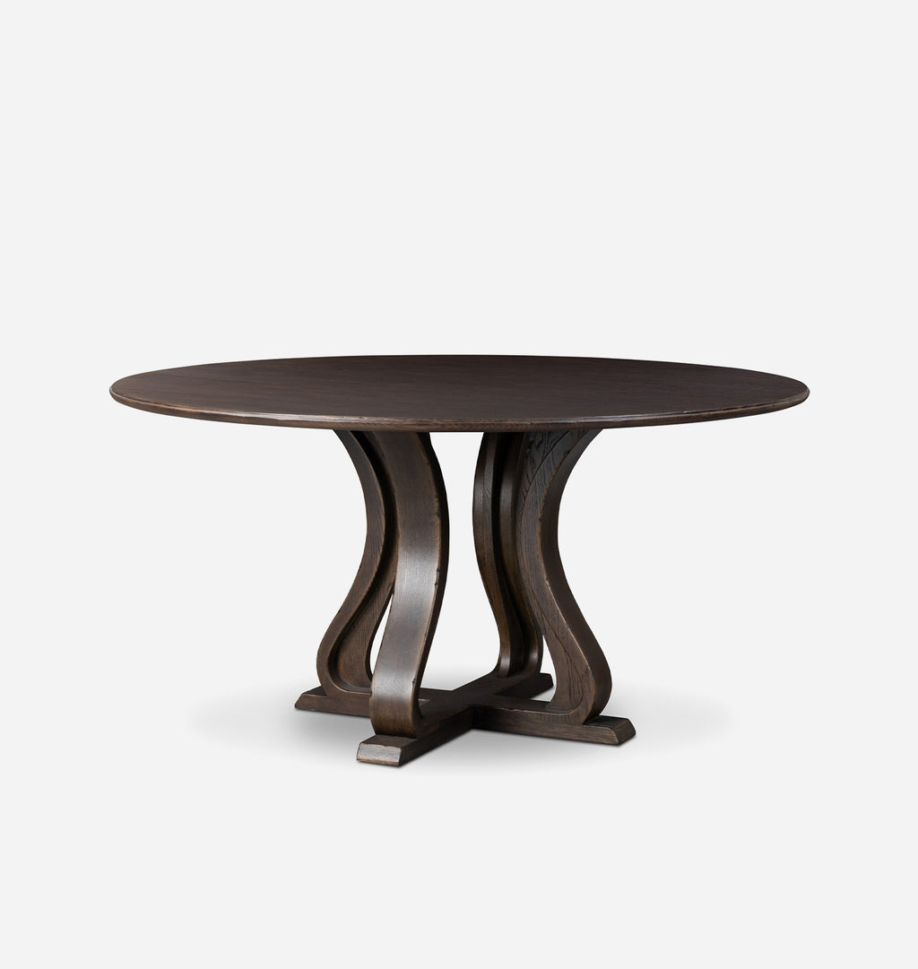 A round dark brown wooden dining table with a sculptural curved pedestal base, shown against a plain light gray background.
