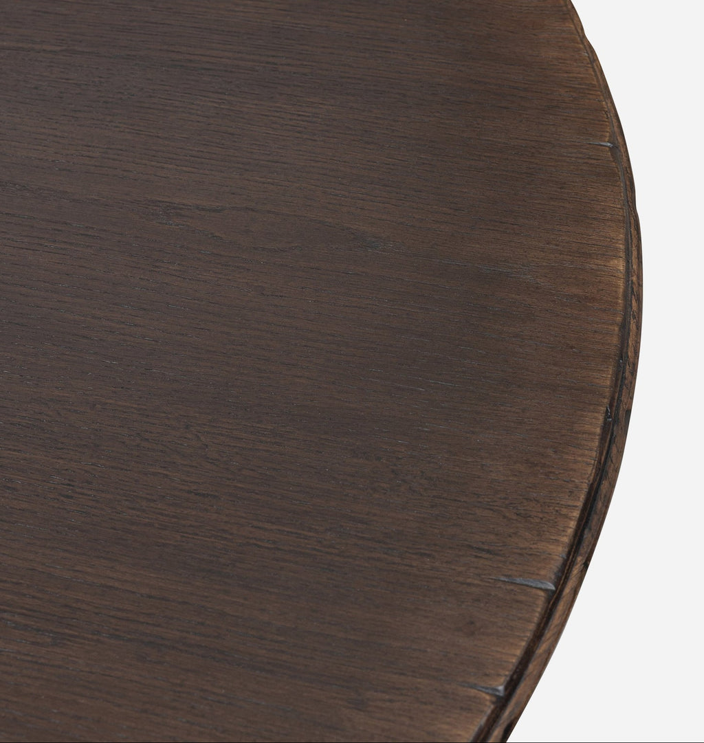 Close-up of a dark brown wooden table surface showing the grain and a curved edge against a light gray background.