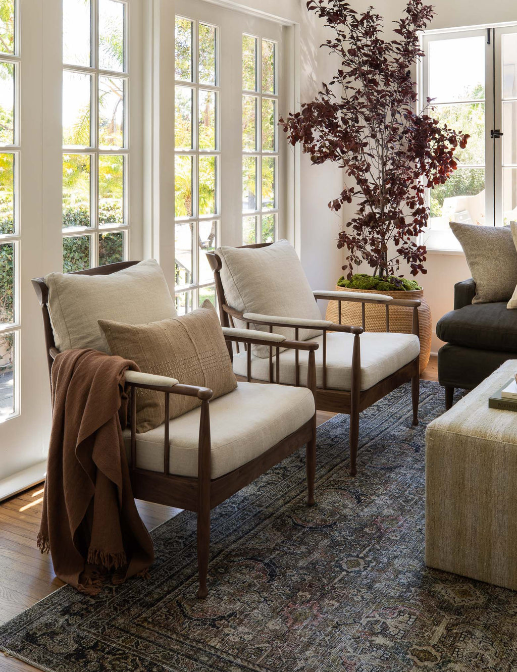 Living room with wooden chairs, a coffee table, and decorative elements.