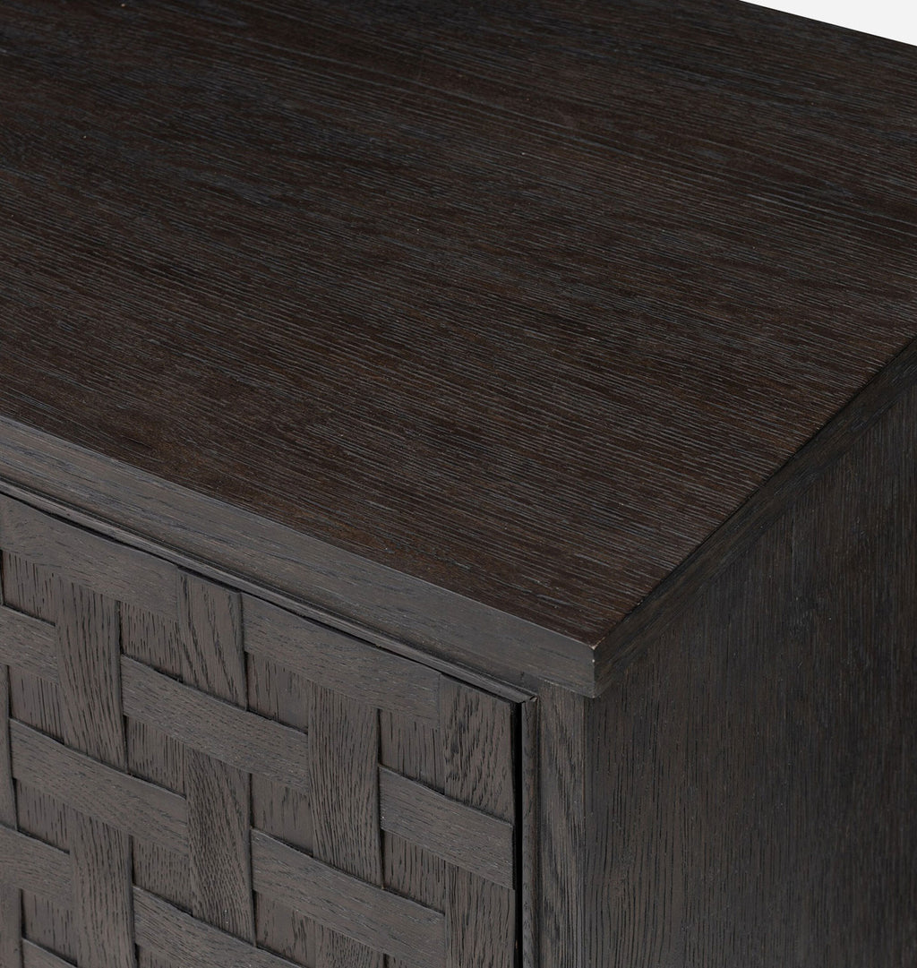 Close-up of a dark brown wooden cabinet with a woven front panel and visible wood grain texture.