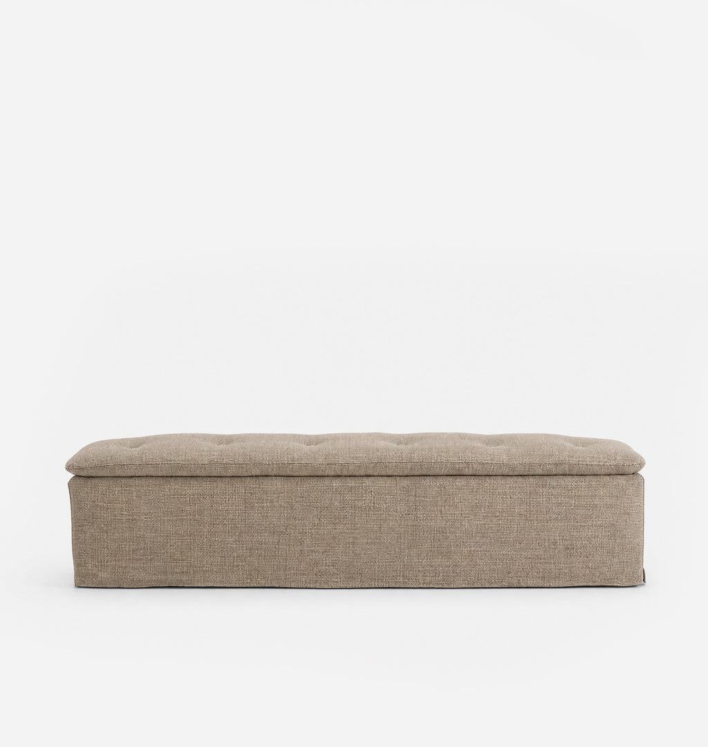 A rectangular upholstered bench with a tufted top cushion, shown from the front against a plain white background.