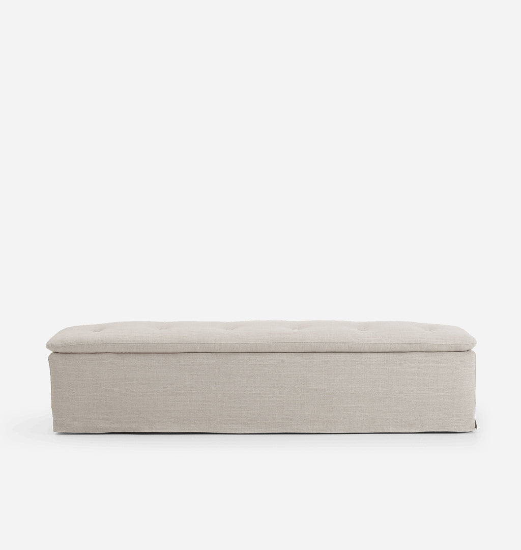 A rectangular upholstered bench with a tufted top cushion, shown from the front against a plain white background.