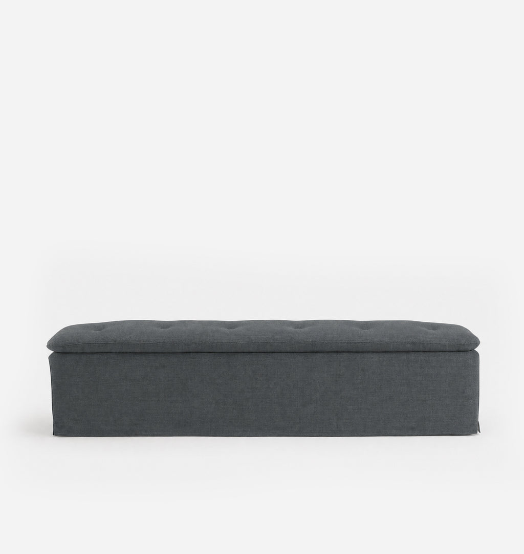 A dark gray upholstered bench with a tufted top, shown from a front-facing perspective against a clean white background.