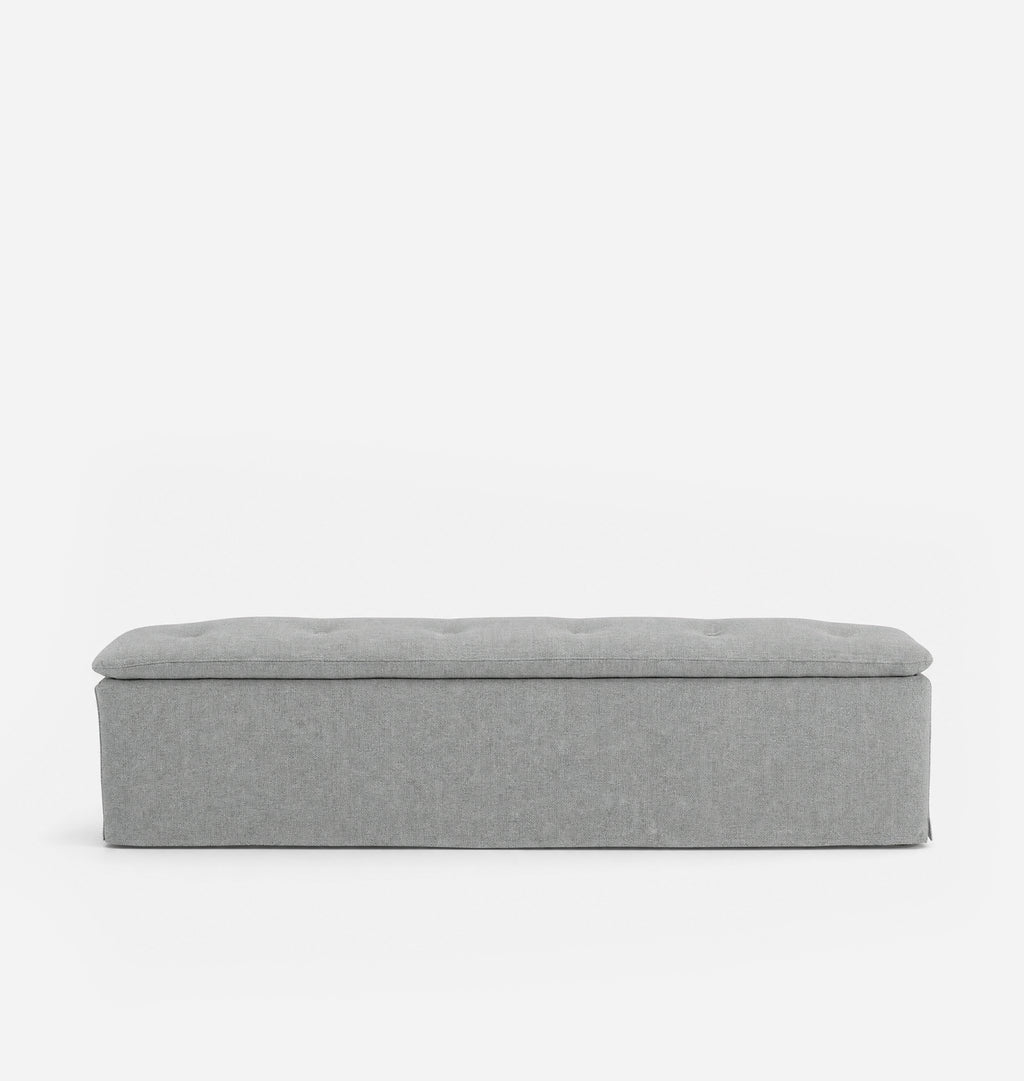 A light gray upholstered bench with a tufted top, shown from the front against a plain white background.