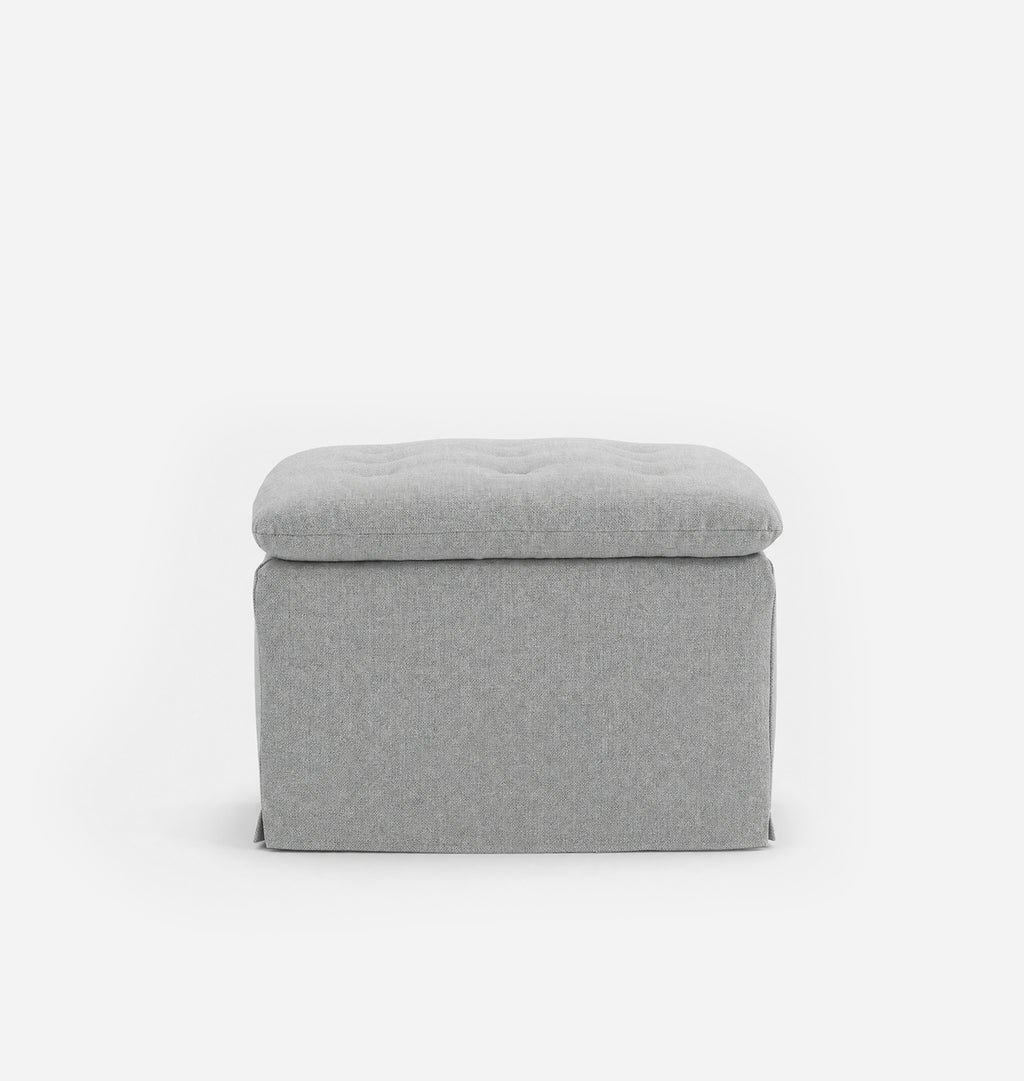 A light gray upholstered ottoman with a tufted seat, shown from the front against a plain white background.