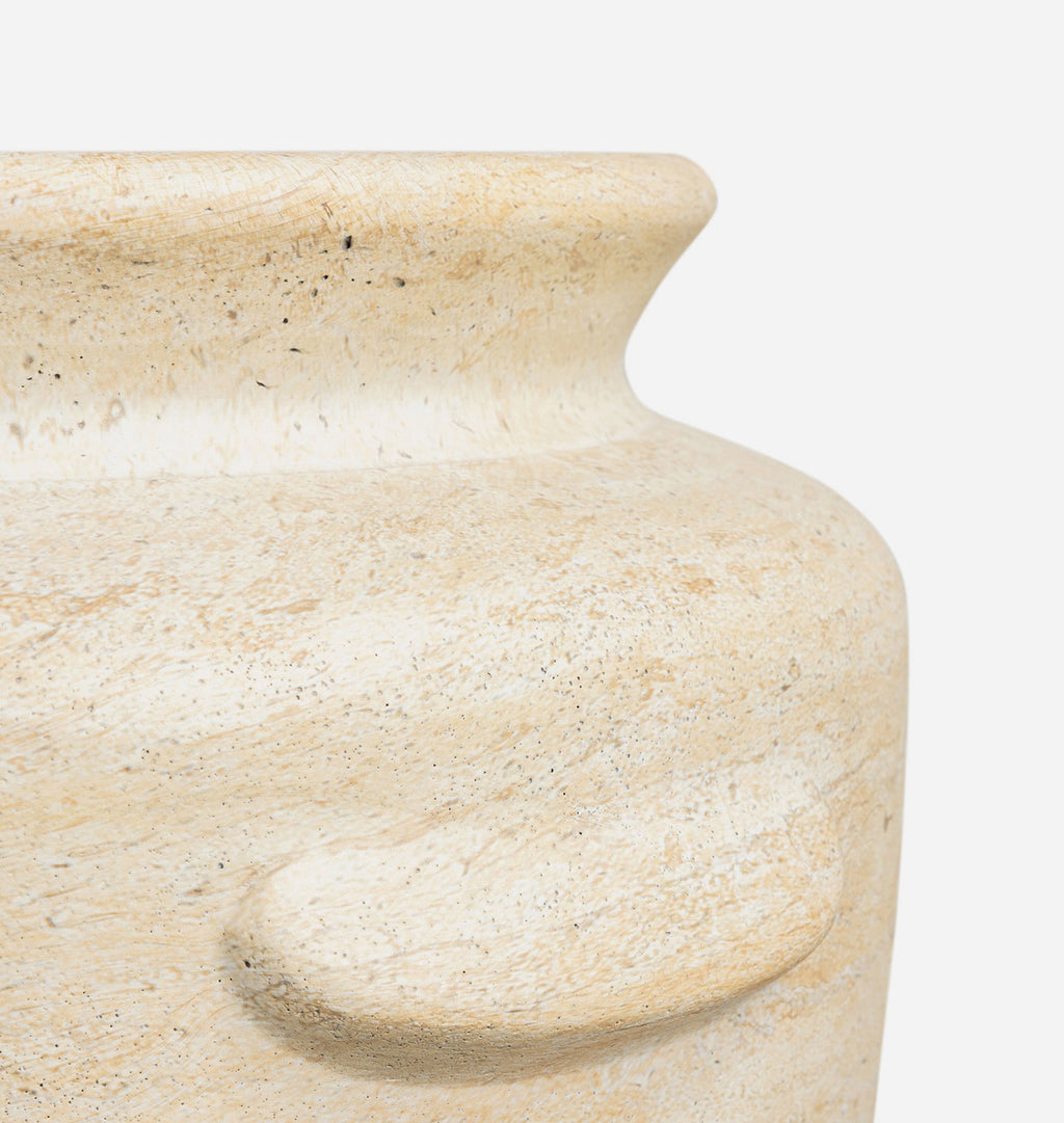 Close-up detail of a textured stone planter or vase in a warm beige travertine finish, showing the flared rim and rounded body against a plain white background.