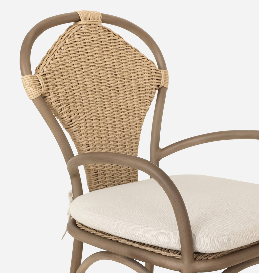 Close-up of a woven rattan armchair with a curved taupe-brown frame and a light beige cushion on a plain white background.