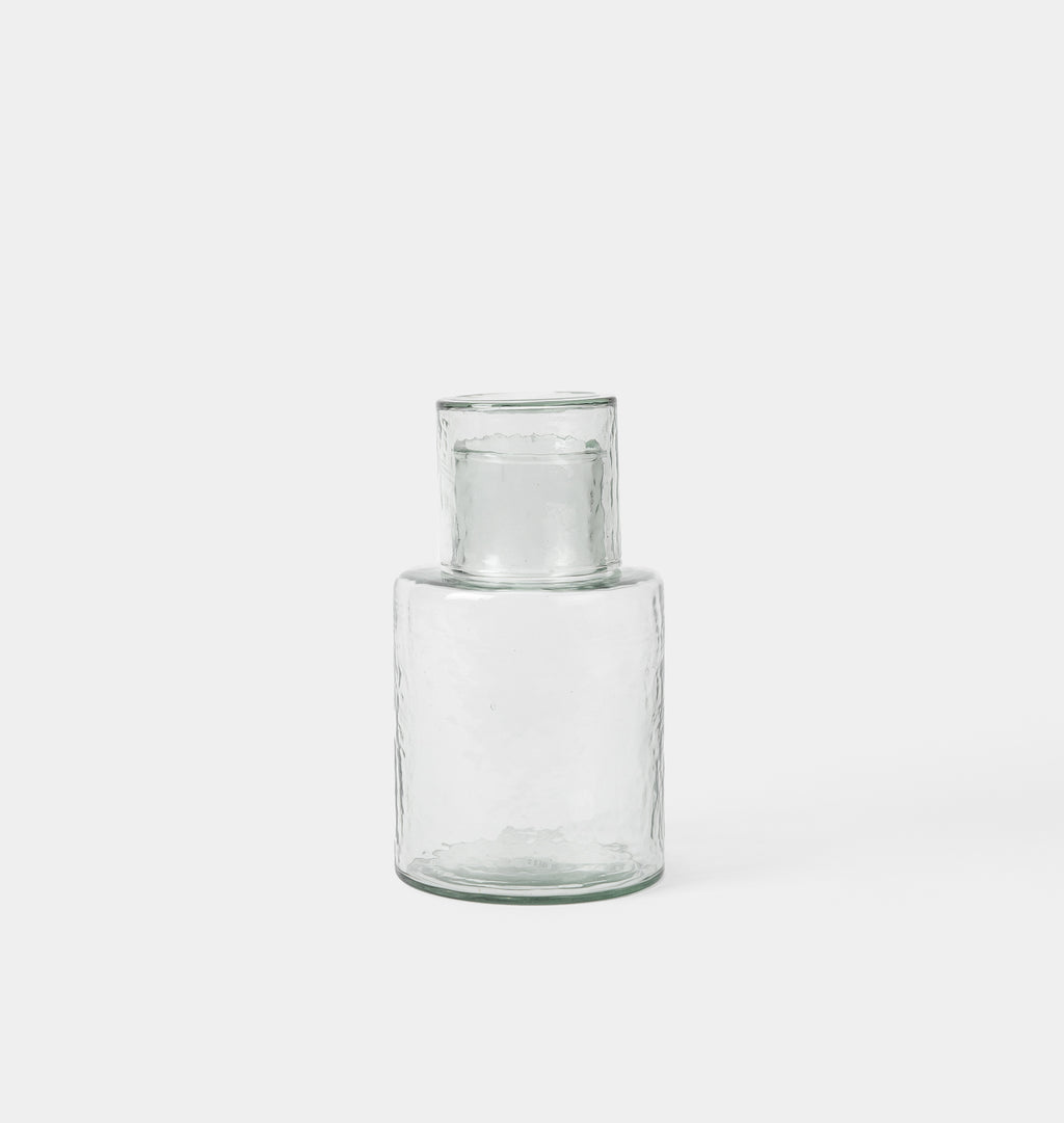 A clear glass vase with a textured, hammered finish and a flared rim, shown against a plain light gray background.