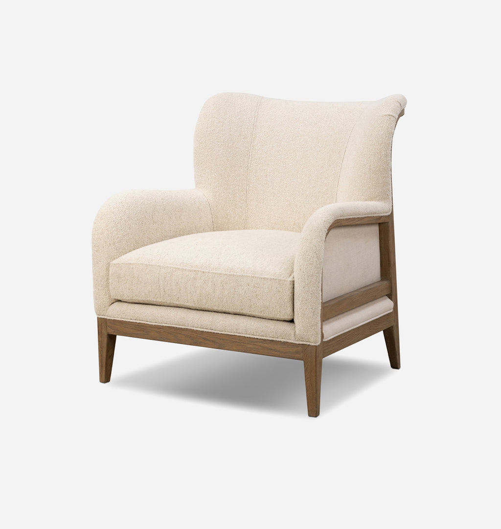 A modern accent armchair with a curved backrest, upholstered in a textured cream bouclé fabric and supported by a medium brown wooden frame with tapered legs, shown on a light gray background.