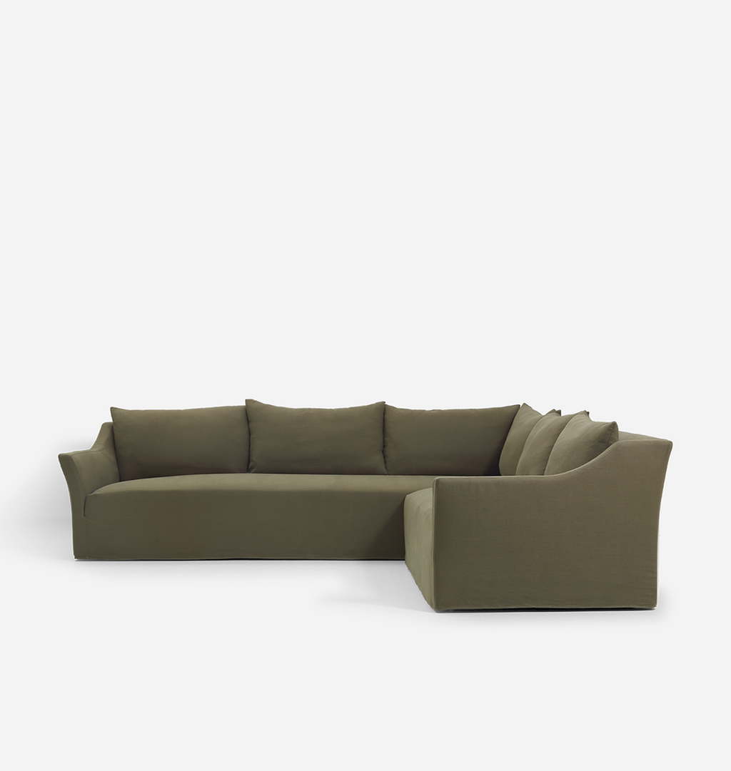 An olive green velvet sectional sofa with matching back cushions, shown from a three-quarters angle against a plain white background.