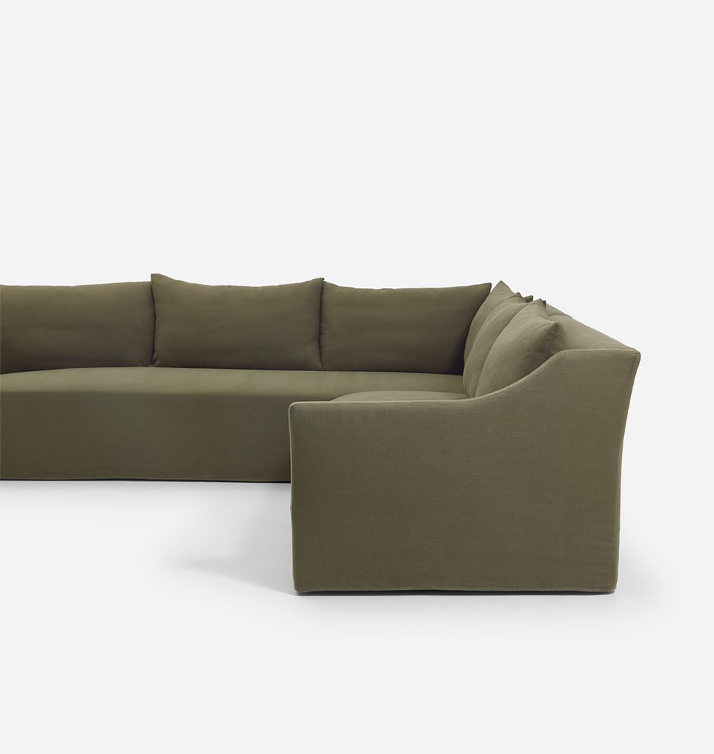 An olive green velvet sectional sofa with matching back cushions, shown from a side angle against a clean white background.