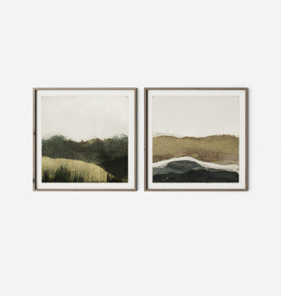 Two framed abstract landscape art prints hanging side-by-side on a plain white wall. The prints feature earthy tones of green, brown, beige, and black, with thin dark frames.