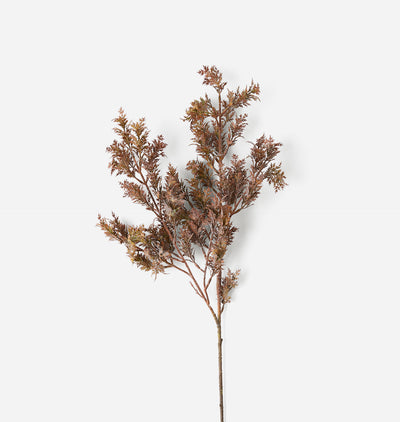 A single artificial branch with dense, feathery foliage in muted brown and bronze tones, isolated on a solid white background.