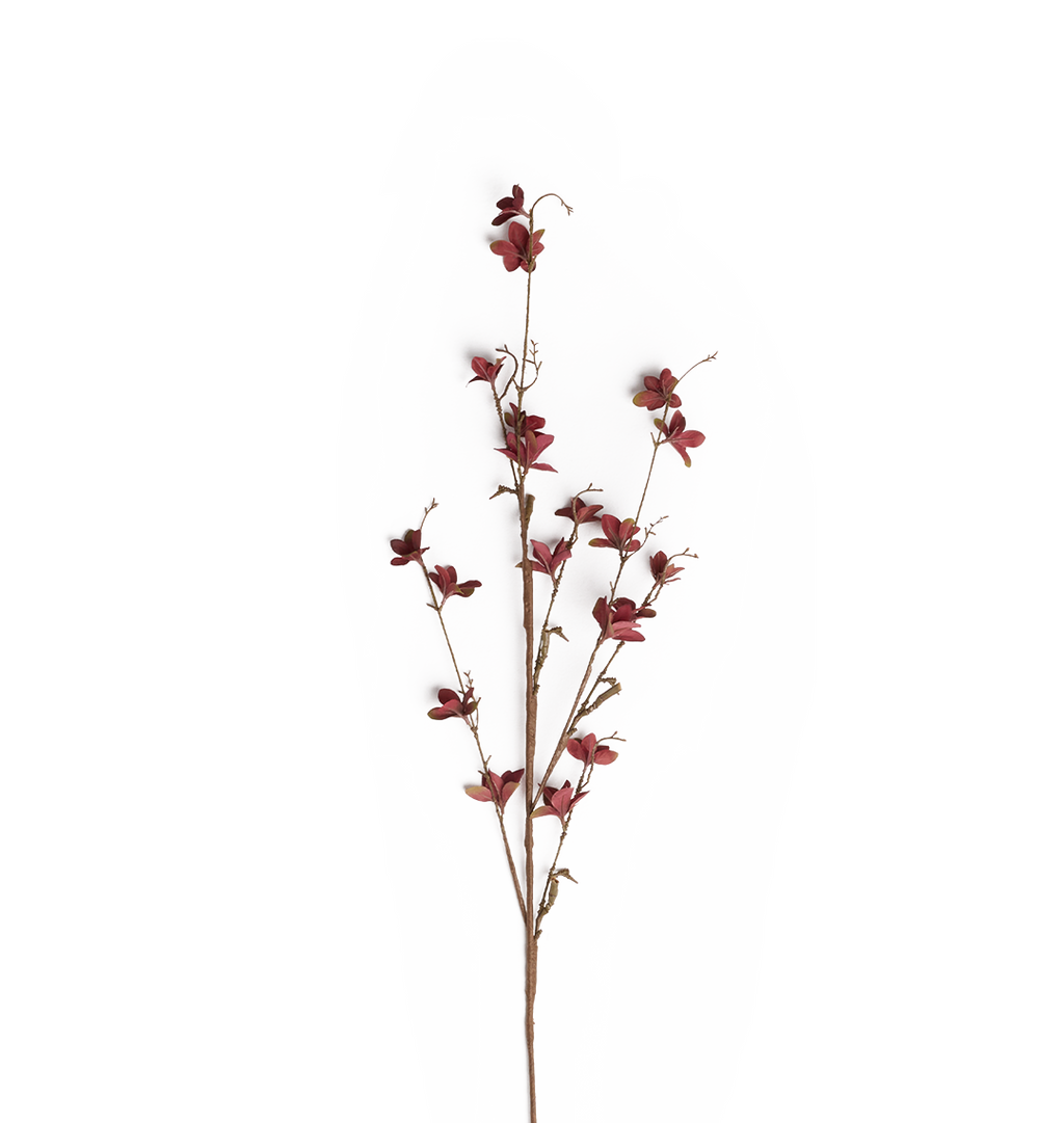 A single artificial flower stem with small dark red blossoms and muted green leaves on a plain white background.
