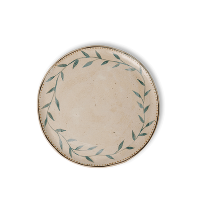 Overhead view of a round ceramic plate with an organic rim, decorated with a green leafy vine border and a gold dotted accent line on a white background