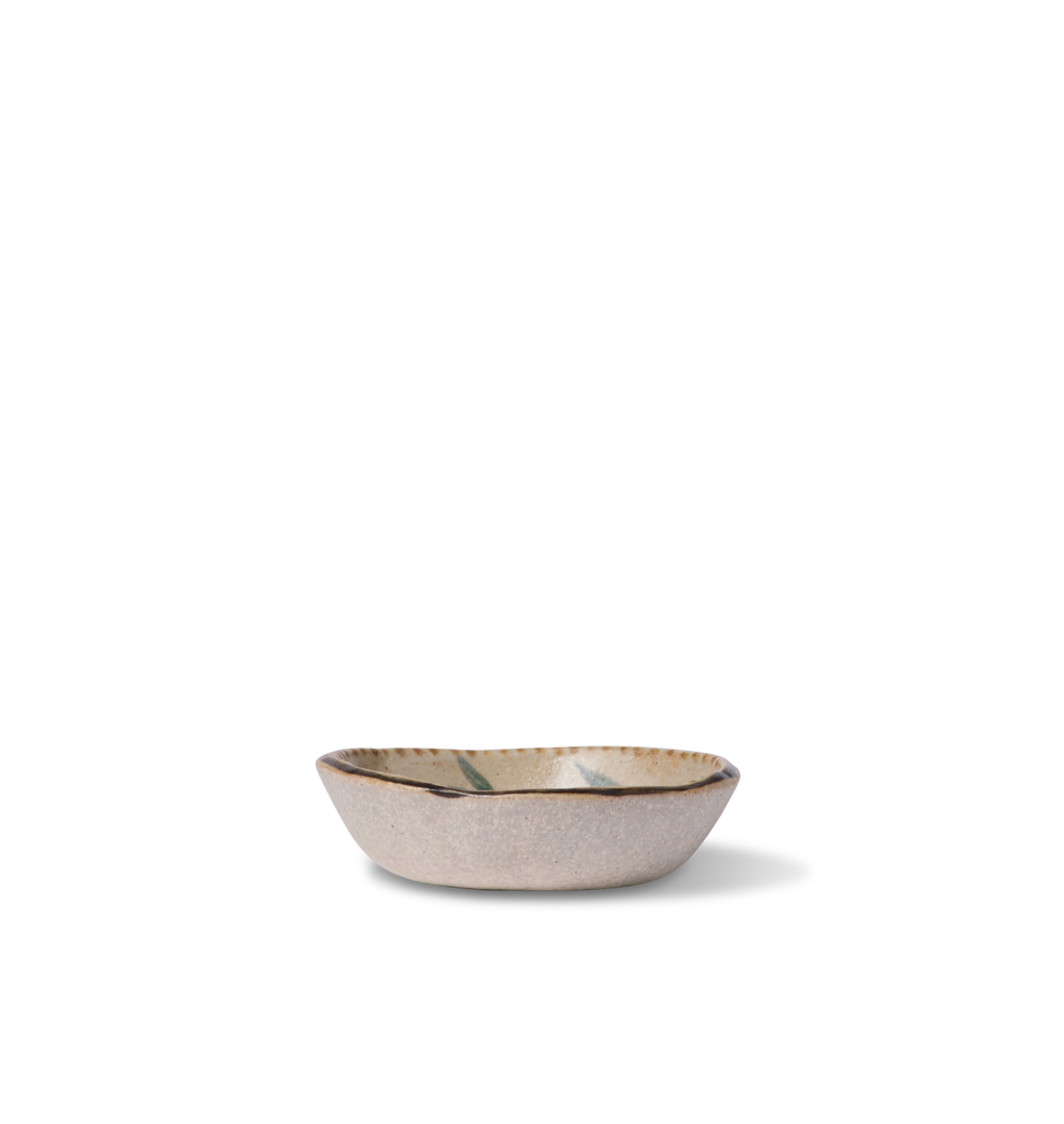 Side view of a round ceramic salt bowl with an organic rim, decorated with a green leafy vine border and a gold dotted accent line on a white background