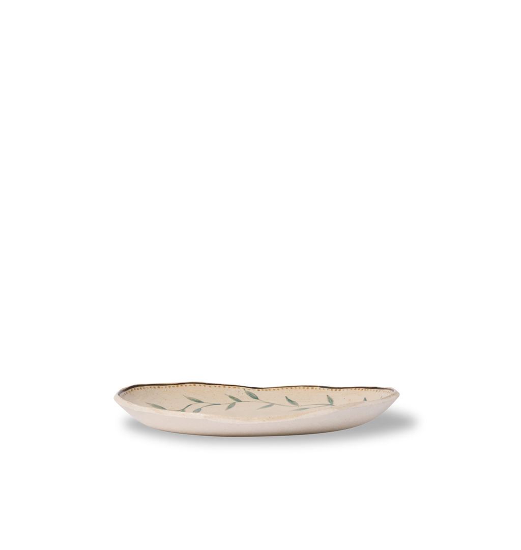 Side view view of an oval ceramic serving platter with an organic rim, decorated with a green leafy vine border and a gold dotted accent line on a white background